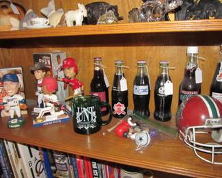 We have an incredible sports memorabilia collection that includes books, bobbleheads, sports banners, commemorative drinks, vintage sports games, & hats.