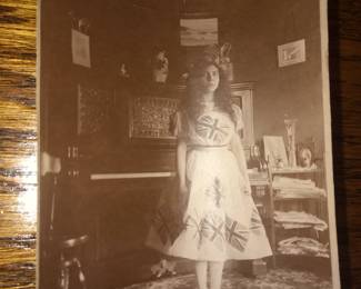 ORIGINAL FISHER FAMILY PHOTO OF YOUNGER WOMAN WITH POTTERY GLASS ITEM ON TOP OF SHELF CLOSE UP VIEW OF RARE MANUFACTURING S IGNED POTTERY GLASS SET OF VASES FROM THE LAWRENCE FISHER ESTATE SALE WITH ORIGINAL PHOTO OF FISHER FAMILY MEMBER IN FRONT OF AND ON THE FIRE PLACE MANTLE.