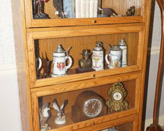Vintage barrister bookcase with steins, clock, and more.