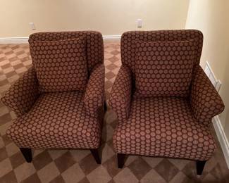 Matching upholstered armchairs, each with a matching pillow.