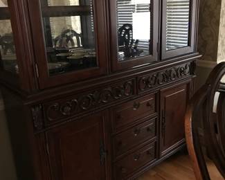 Beautifully carved china cabinet with silver drawer and other drawers and doors for storage. Carving is actually front of drawers.