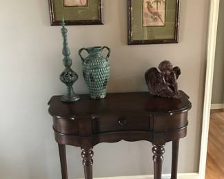 Love this entry table with drawer. Wonderful curve front and braces. Lovely ceramic pottery and framed exotic prints. Sweet Cherub