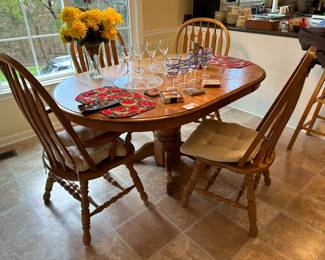 Oak pedestal table with two leaves and four chairs