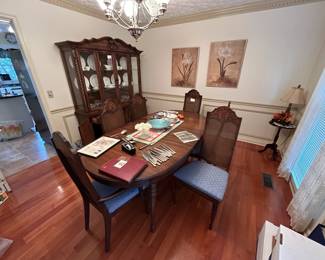Mid Century Modern oak dining table with one leaf and six dining chairs with cane backs and cushioned seats