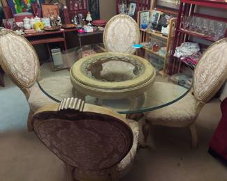 Glass top resin base dining table with 4 upholstered chairs.