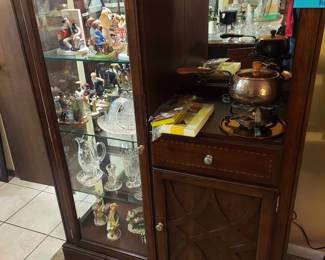 Espresso colored curio cabinet. Approximately 6 feet tall and lighted inside.