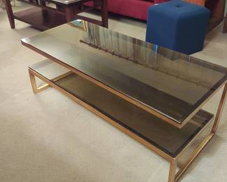 Mid century glass coffee table with built in shelf. Smoked glass with brass colored frame.
