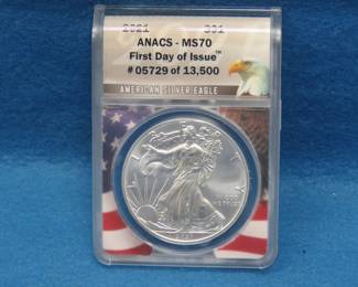 Lot 119. 2021 American Silver Eagle First day of issue containing 1 oz. pure silver graded by ANACS-MS70 in an attractive wooden display box.