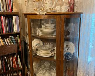 Curved glass China cabinet full of Christmas China and glassware 