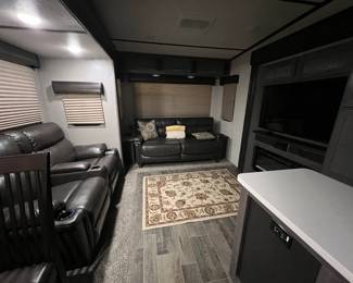 Custom Interior with Leather recliner and loveseat. Flatscreen and fireplace.