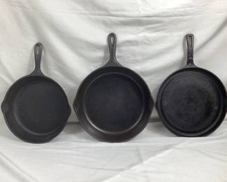 BIHY106 Three Wagner Ware Cast Iron Pans A collection of three Wagner Ware Cast-iron skillets and pans. Includes a large 12 inch pan (size 10), a medium sized 11 inch pan (size 8), and a shallow 11.5 inch fat free frying pan with a moat to catch oil.
