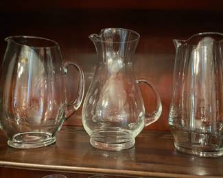 Etched glass and clear glass pitchers.