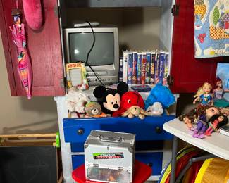 The red, white, and blue cabinet is the perfect size for a child's room. Right below the red stool are 2 bike helmets.
