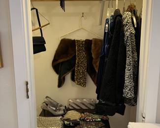 There are several evening dresses, jackets, purses and shoes.