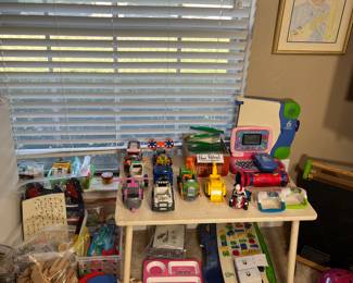 Sitting on this child's table are several toy cars.