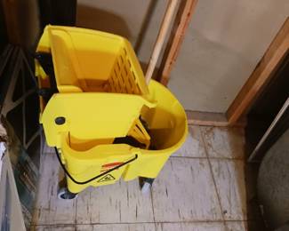 Yellow plastic mop bucket with mop