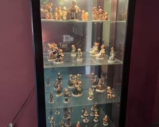 A lighted curio with 31 Hummel Figurines.