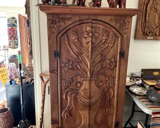 Intricately carved armoire, wooden carved elephants,  antique stoneware jug