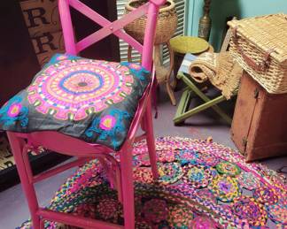 Pink painted Boho tall barstool with pillow...2 round braided rugs underneath.