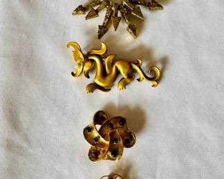 Brooches, including including Brutalist starburst by Zentall (top) and vintage MMA dragon (second from top)
