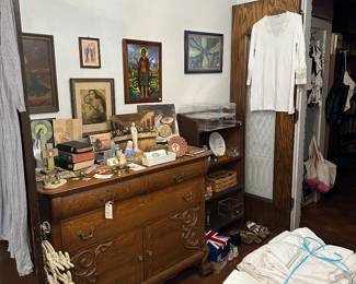 many religious items pictured on top of sideboard