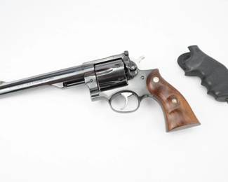 The Super Redhawk was introduced late in 1987, in .44 Magnum with a 9.5-inch barrel. The final product used the same trigger design and same grip panels as the .357 Magnum GP100, but had a larger, stronger frame with integrated scope bases. The Super Redhawk received positive reviews, edging out similar offerings from Smith & Wesson in accuracy and price. This Super Redhawk is chambered in .41 magnum and is in excellent condition, showing normal signs of use and wear. The revolver has an upgraded rubber Houge grip as well as the factory wooden Ruger grips. 