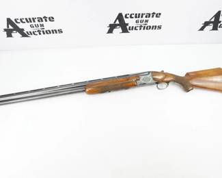Miroku Field Grade over/under shotgun in 12 gauge. This shotgun features a checkered walnut stock and forend with raised cheekpiece, black grip cap, and red Miroku recoil pad, blued receiver with scroll engraving, gold selective trigger, and 30" vent rib barrels. The shotgun is in excellent condition, showing normal signs of use and wear.