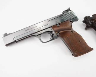 The Smith & Wesson Model 41 is a semi-automatic pistol developed by Smith & Wesson after World War II as a competitive target pistol. It was designed with a 105 degree grip angle, the same as the Colt M1911 pistol, to maintain a consistent grip angle. This 41 is chambered in .22 LR CTG and features a 6.5 inch barrel and is sold with a set of competition grips. The pistol is in excellent condition, showing minimal signs of use and wear.