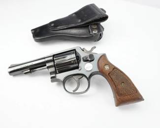 A classic piece of American firearms history – this Smith & Wesson Model 10-8 K Frame Revolver in .38 Special CTG is believed to be from the 1970s or 1980s. This iconic double-action revolver has stood the test of time and remains a favorite among collectors and enthusiasts.. Original wooden grips. Comes with a holster. 