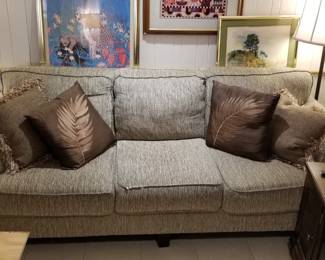 Couch, pillows, picture frames, lamps, so many lamps