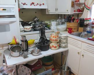 A kitchen packed full of dishes, pots and pans, casserole dishes, etc. etc. 
