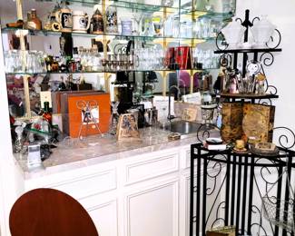 Full bar with bar tools, decanters, stemware. Calvin and Hobbs book set, time clock, corner bakers rack and leather "book" boxes