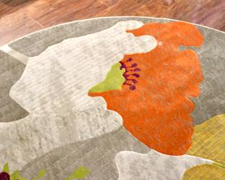 Roung, colorful area rug with floral elements