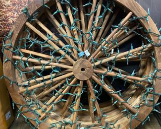 Wagon wheel with Christmas lights adorning it