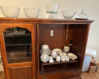 Nice entertainment center and beautiful set of dishes.