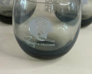 Vintage Mid-Century Modern 1970s Falcons Set of 7 Smoke Gray Tumblers
Each team had a set of lowball cocktail glasses commissioned by the NFL sometime in the 1970s. They are generous 10oz bowls of clear smokey grey blown glass. Each glass is printed in a monochrome tone with both the official NFL logo on one side and the Atlanta Falcons helmet on the other.
Dimensions: Top Circumference 3” x Bottom Circumference 1.5” x Height 3.25”
This set was purchased new and remained with the original owner. She is downsizing and is now available for purchase.
Disclosures: This set is in excellent condition with normal signs of wear for glasses of this age. (Please see the pictures for details.)