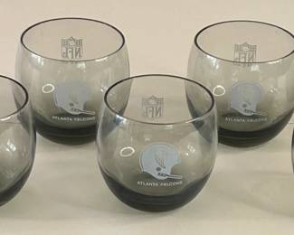 Vintage Mid-Century Modern 1970s Falcons Set of 7 Smoke Gray Tumblers
Each team had a set of lowball cocktail glasses commissioned by the NFL sometime in the 1970s. They are generous 10oz bowls of clear smokey grey blown glass. Each glass is printed in a monochrome tone with both the official NFL logo on one side and the Atlanta Falcons helmet on the other.
Dimensions: Top Circumference 3” x Bottom Circumference 1.5” x Height 3.25”
This set was purchased new and remained with the original owner. She is downsizing and is now available for purchase.
Disclosures: This set is in excellent condition with normal signs of wear for glasses of this age. (Please see the pictures for details.)