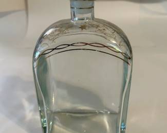Vintage Liquor Bottle from Jerez, Spain, Gild Decorated at the Top, Ribbons & Stars, with Glass Topper, Decanter Style, in Mint Condition. It is a glass liquor bottle with a glass top. The stopper and upper part of the bottle are decorated in hand-painted gold in grapes and ribbon pattern.
This decanter was purchased new in the 1970s during travel and remained with the original owner. She is downsizing and is now available for purchase.
Disclosures: This pristine decanter is in excellent condition with normal signs of wear for a piece of this age, although it has NO cracks or chips. (Please see the pictures for details.)
Dimensions: 4.25" Width x 2.5" Depth x 8.25" Height
Weight: 1.15 Pounds