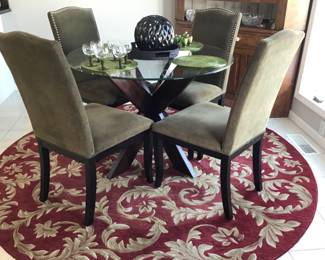 Beautiful round area rug, very nice glass table with “5” chairs 