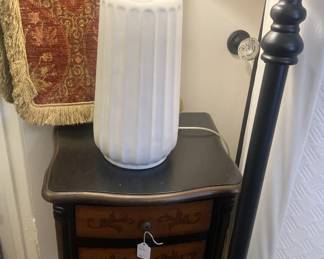 One of two small black matching side tables; one of two matching white lamps