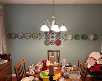 Dining room chock full of dishes, napkins, tablecloths, and wall art.  Dining table and chairs and chest kept by family.   