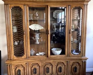 Beautiful lighted china cabinet.  The brass work on the glass is beautiful,  Imagine a redo in dark blue, green or black - make that brass POP!
