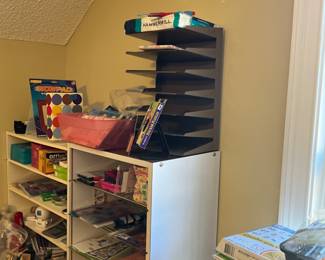 Craft and office supplies, scrapbooking paper, stickers, pens, pencils, markers.