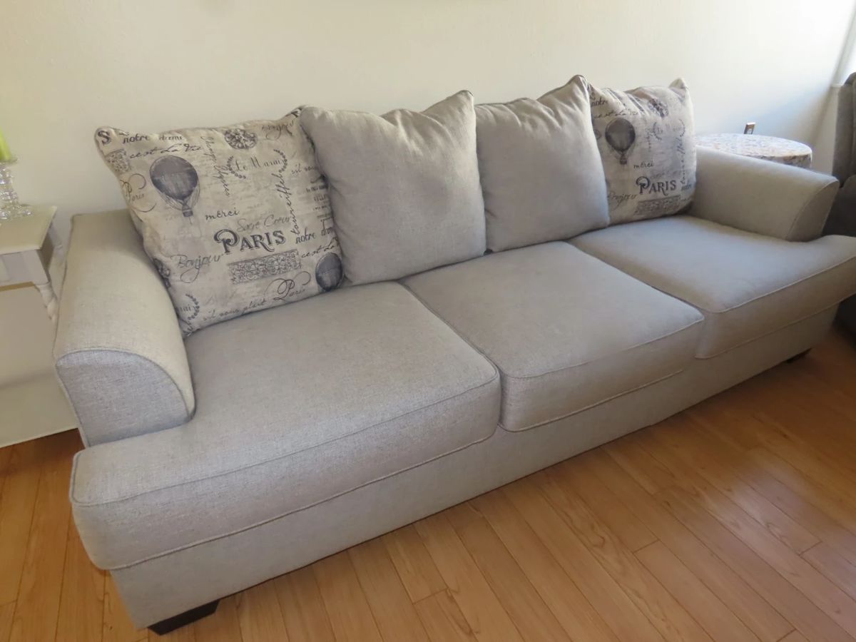 Lovely like new grey fabric queen size sleeper sofa with throw pillows.
