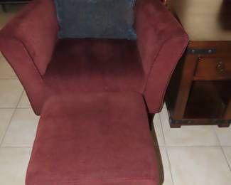 One of two matching armchairs with foot stools.