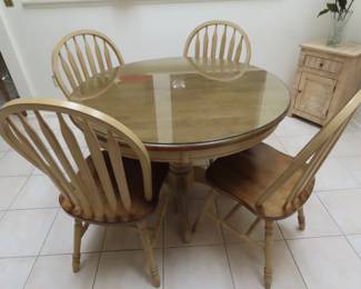 Round dining table with glass topper and 4 chairs.