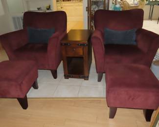 Two matching armchairs with foot stools.