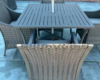 Available for Presale. O1- 4 Wicker Chairs & Metal Table with Umbrella. Tops of Chair backs have wear & tear. Slight hole on top of table where umbrella is. 42"D x 41"W x H 29". Chair Back 34"Hx W9" x D19". Seat 20"