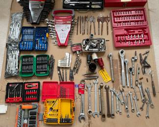 2 sets of combination wrenches, several partial sets of bits, assorted loose wrenches, drivers, and other items I'm not familiar with.  Some drill bits.