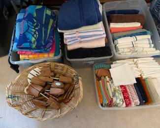 Beach towels, shoe shaper inserts, wicker laundry basket, bath towels, kitchen towels, dish drying towels.
